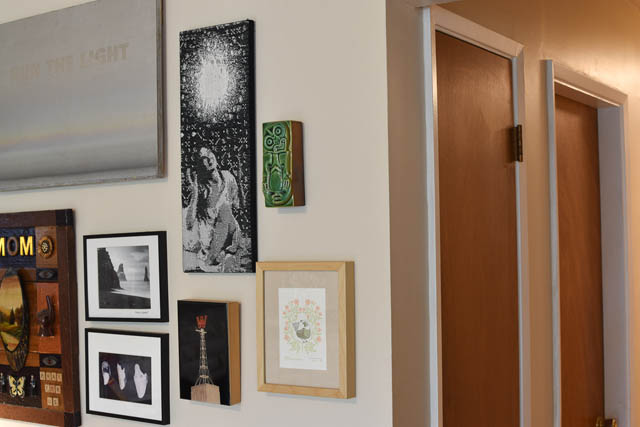Bright living room with eclectic wall art and open door leading to another room. - 850 E 23rd Avenue, Vancouver East Side