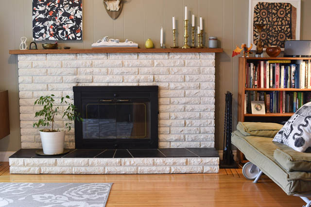 Living room with stone fireplace, hardwood floors, and bookshelf. - 850 E 23rd Avenue, Vancouver East Side