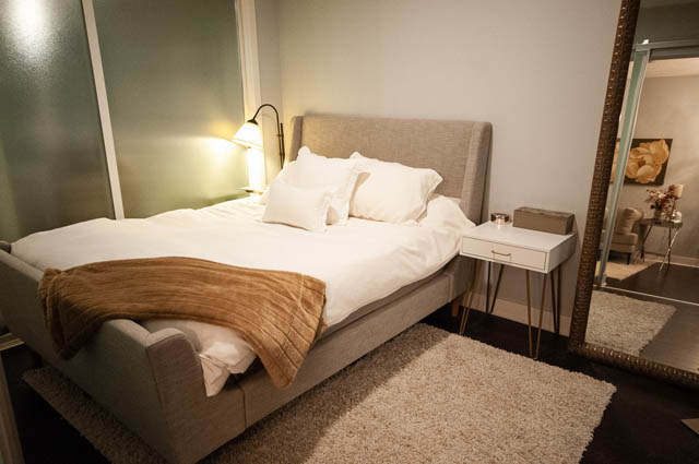 Furnished bedroom with a cozy bed, soft lighting, and a plush rug. - 105 - 2020 W 12th Ave, Vancouver West Side