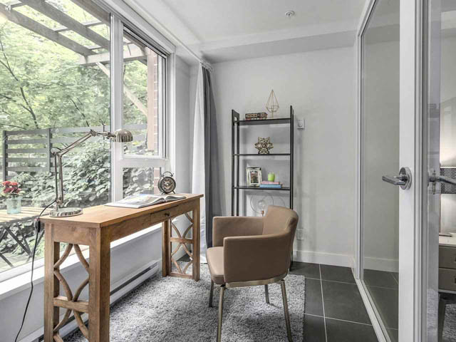 Furnished home office with large windows, wooden desk, and cozy chair. - 105 - 2020 W 12th Ave, Vancouver West Side