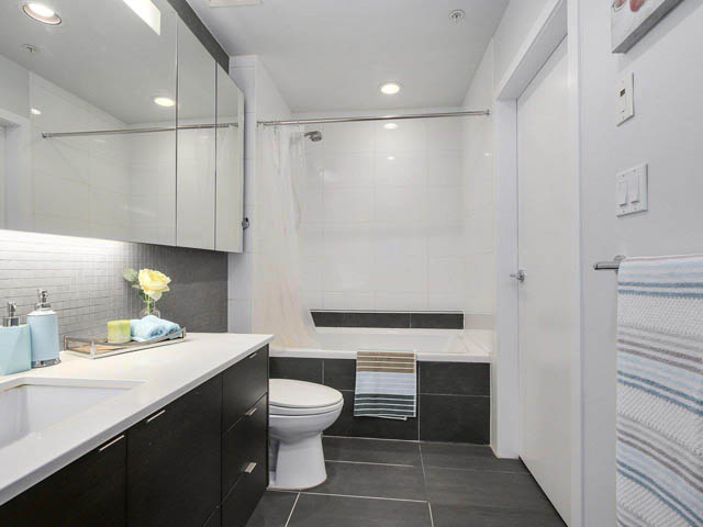 Bright bathroom with white countertops and a walk-in shower. - 105 - 2020 W 12th Ave, Vancouver West Side