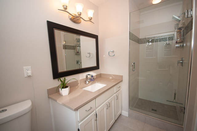 Spacious bathroom with modern vanity and glass shower, neutral tones. - 1528 Edgewater Lane, North Vancouver