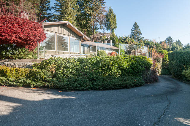 Furnished living room with large windows and greenery surrounding. - 3399 Thompson Cres., West Vancouver