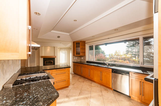 Bright kitchen with granite countertops, hardwood floors, and a city view. - 3399 Thompson Cres., West Vancouver