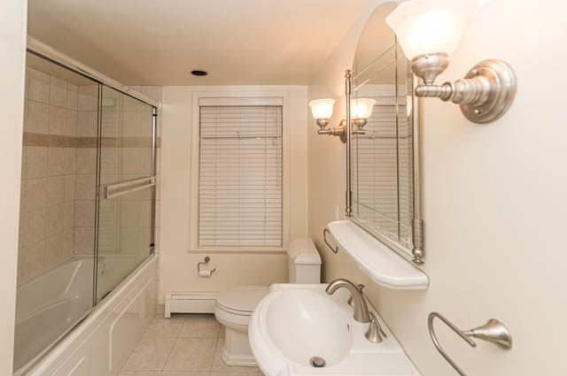 Spacious bathroom with white fixtures, large mirror, and glass shower. - 3399 Thompson Cres., West Vancouver