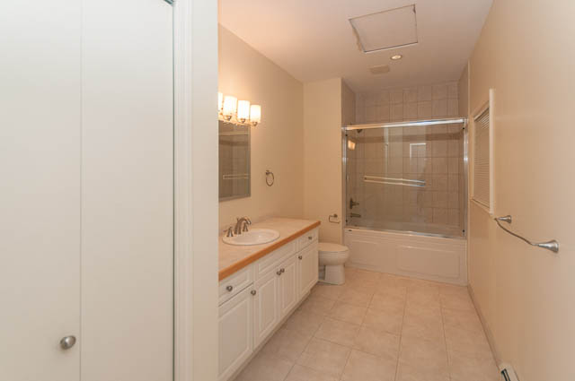 Bright bathroom with white cabinetry and beige tile flooring. - 3399 Thompson Cres., West Vancouver