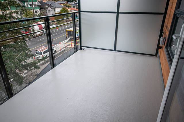Spacious balcony with city view and modern glass doors. - 404 - 733 E 3rd St, North Vancouver