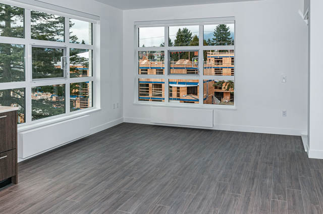 Bright living room with hardwood floors and city view. - 404 - 733 E 3rd St, North Vancouver