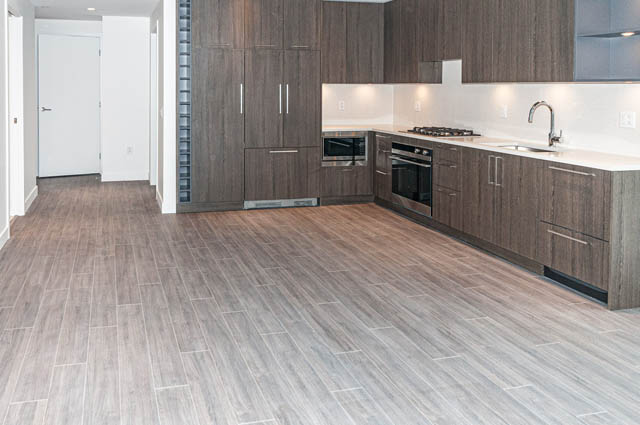 Bright kitchen with modern cabinetry, stainless steel appliances, and hardwood floors. - 404 - 733 E 3rd St, North Vancouver