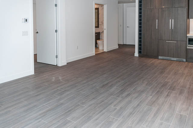 Open kitchen with modern cabinets and hardwood floors. - 404 - 733 E 3rd St, North Vancouver