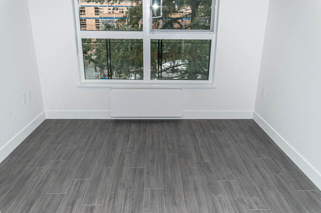 Bright living room with hardwood floors and city view. - 404 - 733 E 3rd St, North Vancouver
