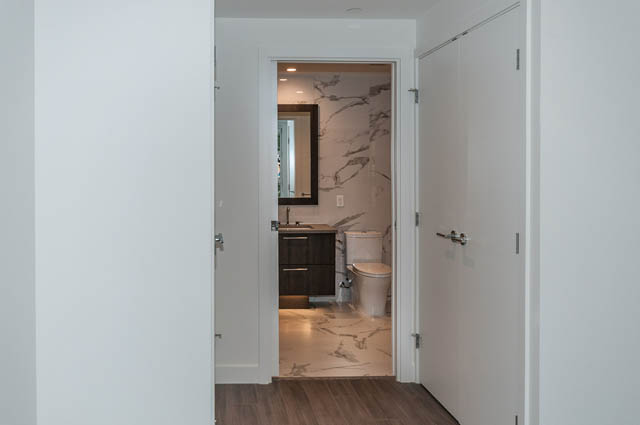 Bathroom with marble walls and modern fixtures. - 404 - 733 E 3rd St, North Vancouver