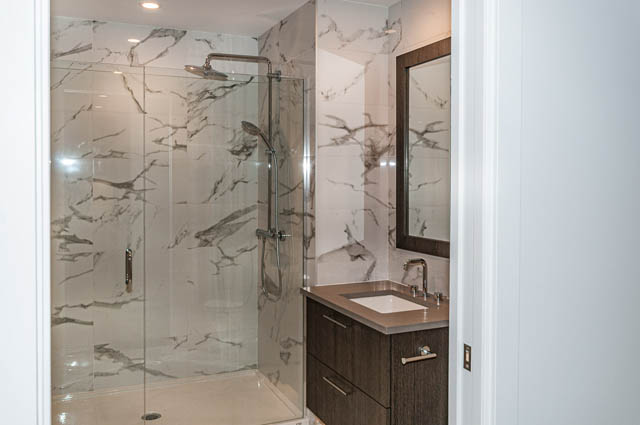 Furnished bathroom with marble shower and countertop. - 404 - 733 E 3rd St, North Vancouver