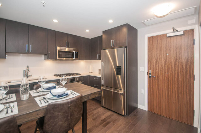 Modern kitchen with dark wood cabinets, stainless steel appliances, and hardwood floors. - 401 - 1708 Ontario Street, Vancouver West Side