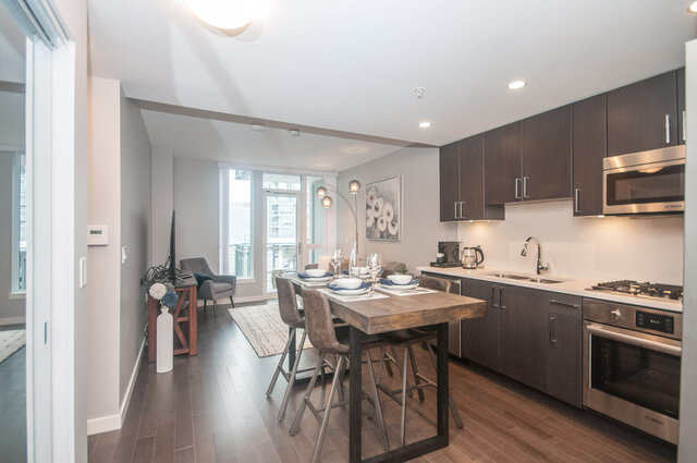 Open-concept kitchen and dining area with hardwood floors, modern appliances, and a city view. - 401 - 1708 Ontario Street, Vancouver West Side