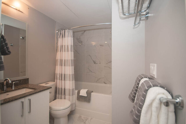 Spacious bathroom with marble tiles, granite countertop, and modern fixtures. - 401 - 1708 Ontario Street, Vancouver West Side