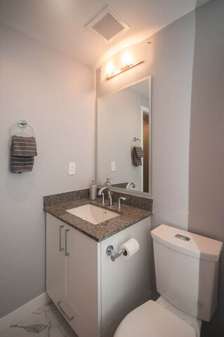 Bathroom with granite countertop, modern sink, and wall-mounted toilet. - 401 - 1708 Ontario Street, Vancouver West Side