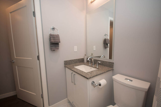 Modern bathroom with granite countertops and a sleek vanity, offering a clean and contemporary look. - 401 - 1708 Ontario Street, Vancouver West Side