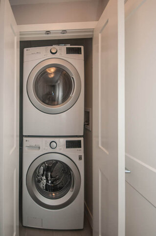 Compact laundry area with stacked washer and dryer, ideal for small spaces. - 401 - 1708 Ontario Street, Vancouver West Side