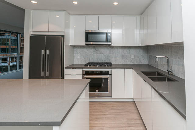 Bright kitchen with modern appliances, granite countertops, and city view. - 404 - 2632 Library Lane, North Vancouver