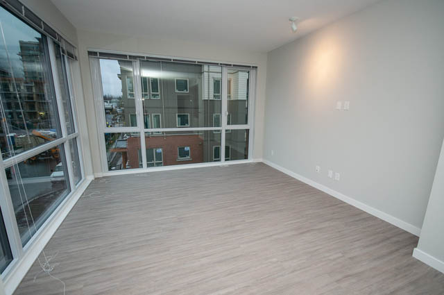 Bright living room with hardwood floors and city view. - 404 - 2632 Library Lane, North Vancouver