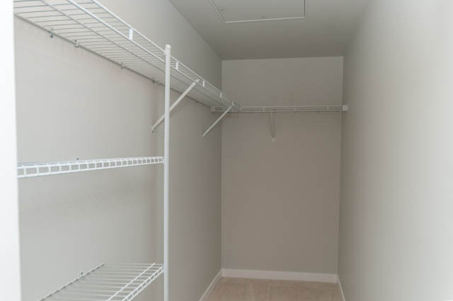Empty closet with white shelves and rods. - 404 - 2632 Library Lane, North Vancouver