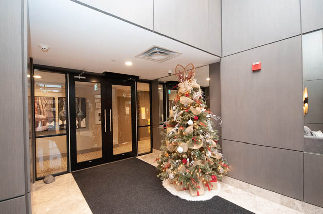Festively decorated living room with Christmas tree and modern decor. - 404 - 2632 Library Lane, North Vancouver