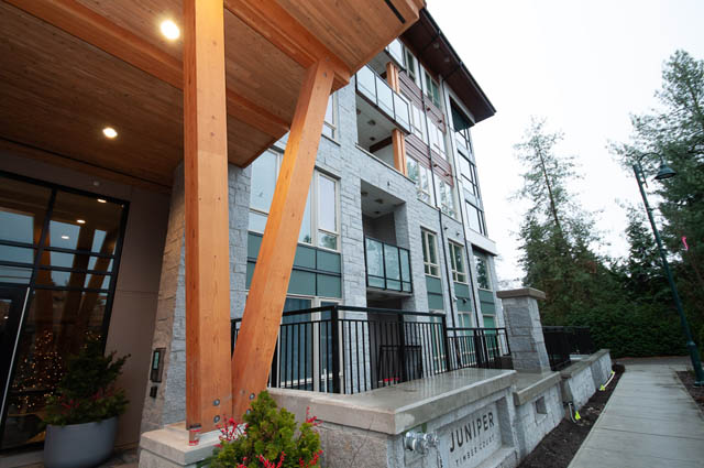 Furnished living room with modern decor and outdoor access. - 404 - 2632 Library Lane, North Vancouver