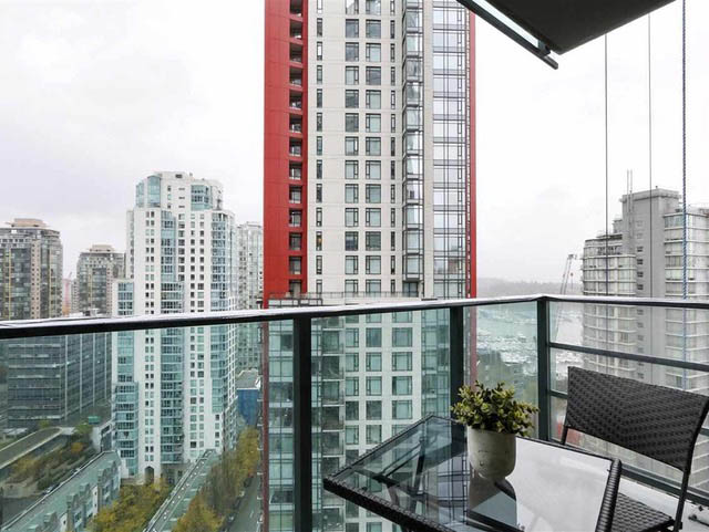 Furnished balcony with glass railings, city view, and modern furniture. - 2407 - 1189 Melville Street, Vancouver Downtown
