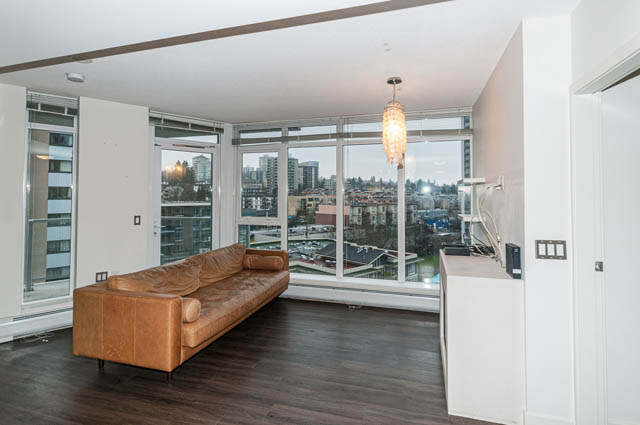 Bright living room with hardwood floors, city view, and modern decor. - 1001 - 175 West 2nd Street, North Vancouver