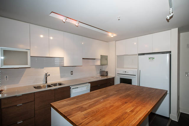 Bright kitchen with white cabinetry, hardwood floors, and a city view. - 1001 - 175 West 2nd Street, North Vancouver