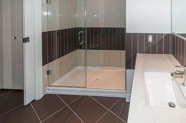 Bathroom with glass shower, modern sink, and dark wood accents. - 1001 - 175 West 2nd Street, North Vancouver