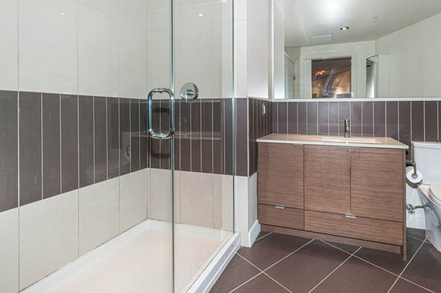 Furnished bathroom with wood vanity and glass shower, modern design. - 1001 - 175 West 2nd Street, North Vancouver