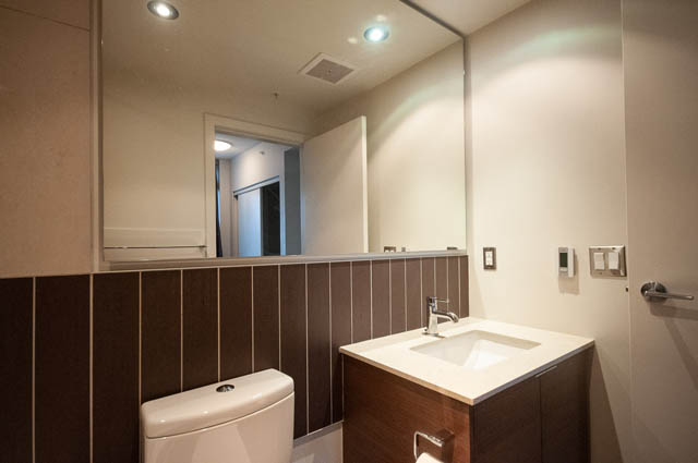 Furnished bathroom with modern sink and large mirror, neutral tones. - 1001 - 175 West 2nd Street, North Vancouver
