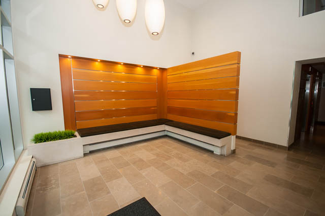 Furnished living room with modern wood paneling and tiled flooring. - 1001 - 175 West 2nd Street, North Vancouver