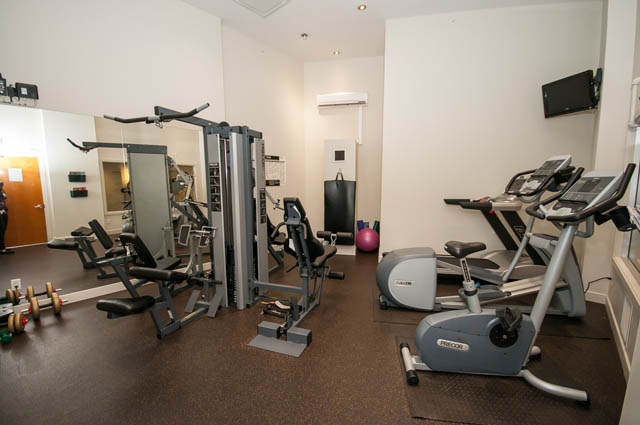 Bright gym with cardio machines and weight equipment, clean and organized. - 1001 - 175 West 2nd Street, North Vancouver
