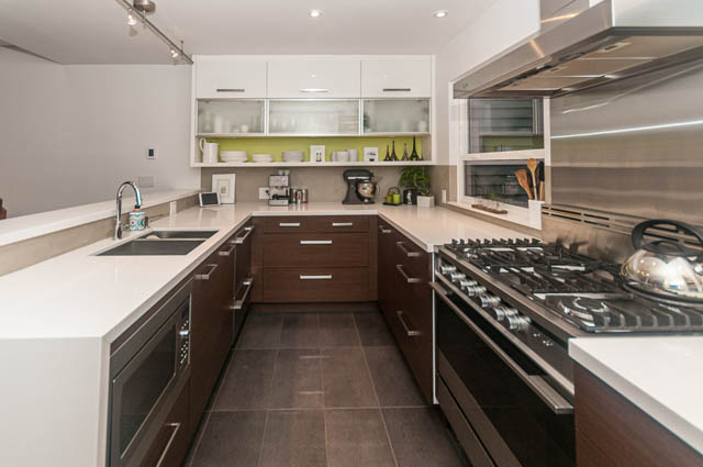 Bright kitchen with white countertops and dark wood cabinets, modern appliances. - 1964 W 15th Ave, Vancouver West Side