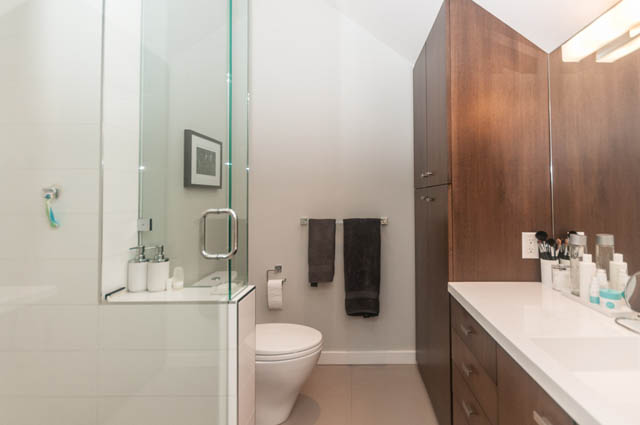 Furnished bathroom with white countertops and wooden cabinets. - 1964 W 15th Ave, Vancouver West Side