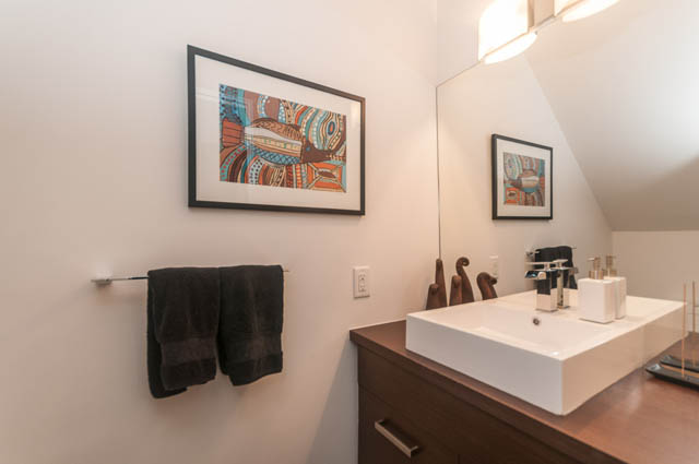 Bright bathroom with white countertops and framed art on the wall. - 1964 W 15th Ave, Vancouver West Side