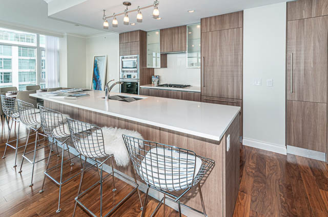 Bright kitchen with white countertops, hardwood floors, and a city view. - 702 - 185 Victory Ship Way, North Vancouver