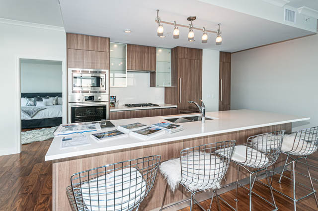 Bright kitchen with white countertops and hardwood floors, modern design. - 702 - 185 Victory Ship Way, North Vancouver