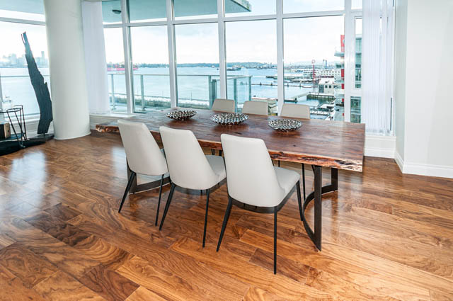 Bright dining room with hardwood floors, city view, and modern furniture. - 702 - 185 Victory Ship Way, North Vancouver