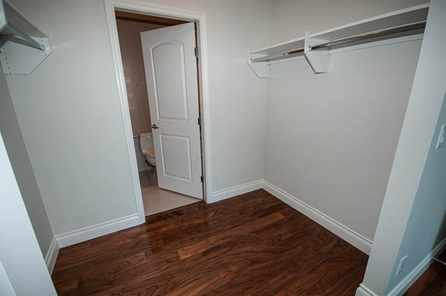 Bright walk-in closet with hardwood floors and white walls. - 702 - 185 Victory Ship Way, North Vancouver