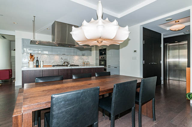 Bright kitchen with modern island, dark countertops, and stylish pendant light. - 601 - 1560 Homer Mews, Vancouver Downtown