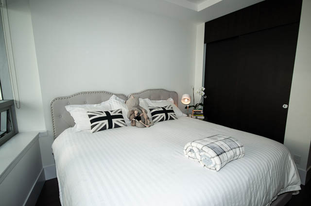 Furnished 3-bedroom bedroom with striped bedding and black accent wall. - 601 - 1560 Homer Mews, Vancouver Downtown