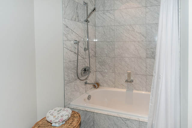 Furnished bathroom with marble tiles and a shower. - 601 - 1560 Homer Mews, Vancouver Downtown