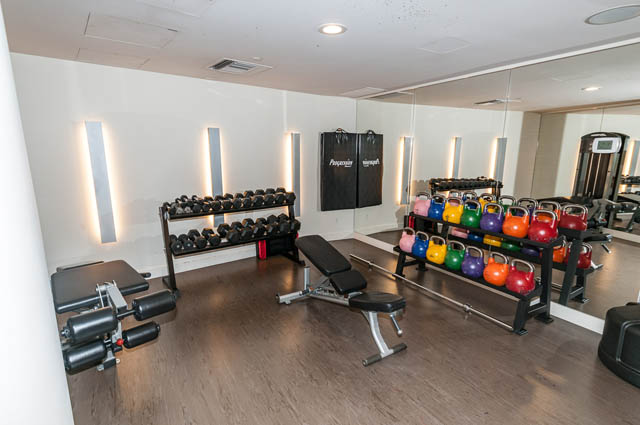 Bright gym with kettlebells and dumbbells, hardwood floors. - 601 - 1560 Homer Mews, Vancouver Downtown