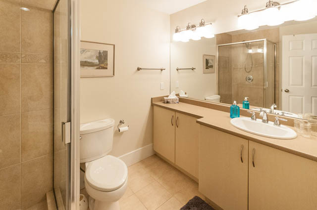 Bright bathroom with beige countertops and a large mirror. - SUITE - 2806 Munday Place, North Vancouver