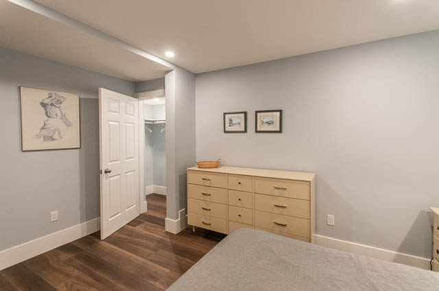 Furnished bedroom with wooden floors, light wood cabinetry, and a modern countertop. - SUITE - 2806 Munday Place, North Vancouver