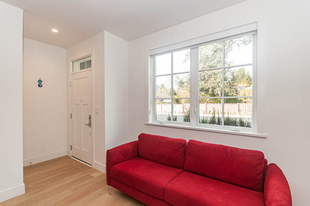 Bright living room with hardwood floors and large windows, showcasing a city view. - 9 - 1133 Ridgewood Drive, North Vancouver